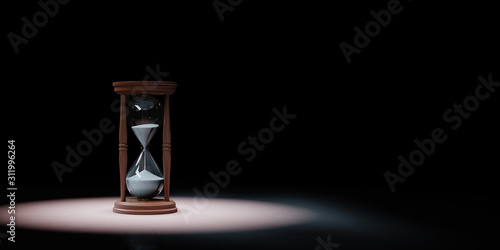 Classic Wooden Hourglass Spotlighted on Black Background