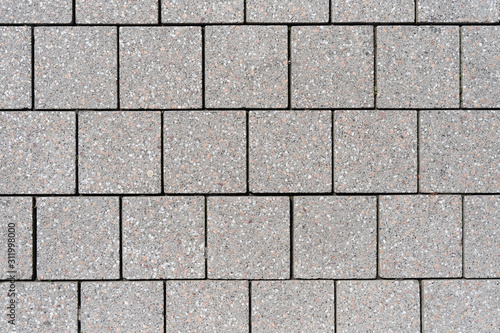 The texture of the square paving slabs of gray in a European city