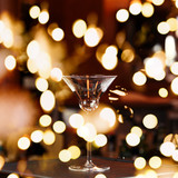 Empty glass on the bar stand. Ready for making cocktail. Square with festive bokeh lights