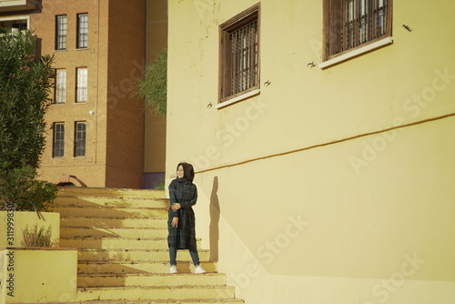 Wallpaper Mural Moslem young girl posing against the background of colorful houses in the city of Villajoyosa, province of Alicante, Autonomous community of Valencia, Spain Torontodigital.ca