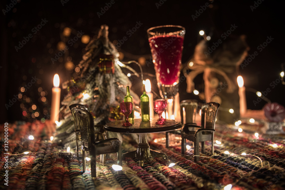 Red wine in crystal glass with bottle on colorful carpet with creative New Year artwork decorations. Copy space