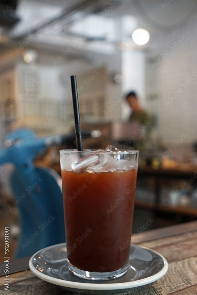 Close up glass of iced black coffee on wooden table Close up glass of iced black coffee on wooden table