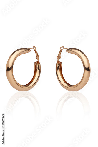 Fotografie Subject shot of a pair of golden earrings isolated on the white background with reflexion