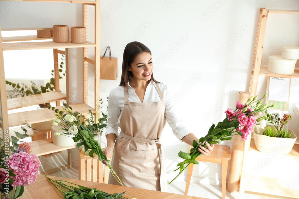 Florist making beautiful bouquet at table in workshop Florist making beautiful bouquet at table in workshop