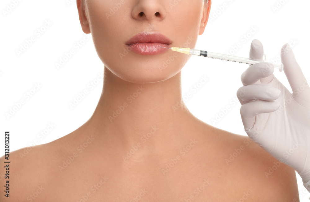 Woman getting lip injection on white background, closeup Woman getting lip injection on white background, closeup