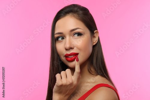 Beautiful woman with red lipstick on pink background