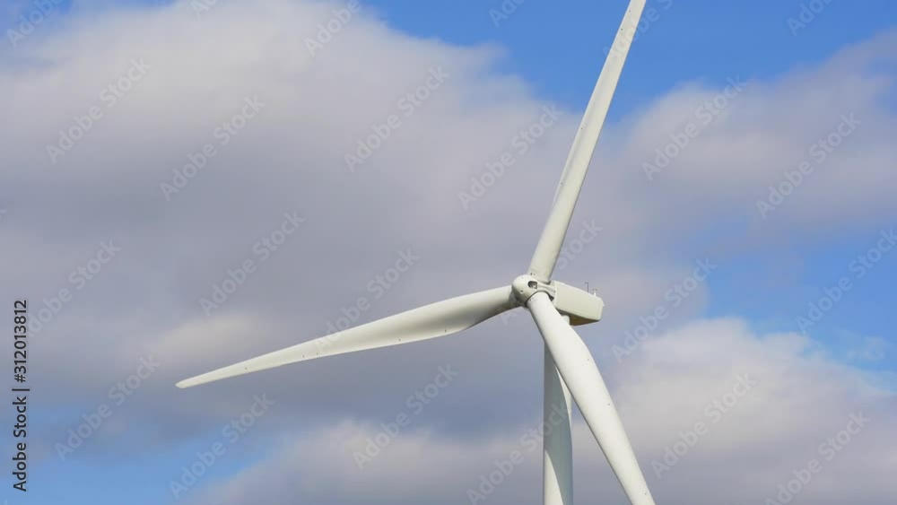 Rotating wind turbine producing alternative energy on a sky background Rotating wind turbine producing alternative energy on a sky background