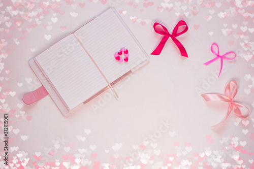 Valentines day flatlay. Blank diary, pink heartshaped beads, hearts and purple ribbon bow on white background. Notebook mockup,cute bokeh lights. Space for wishes text, sign. Lovers day,8 march banner © KawaiiS
