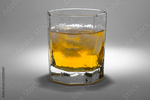 A glass of whiskey with ice on the white background.