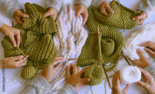 group of woman hand with knitting needles, knit wool white and mossy green scarf for winter handmade gift photo