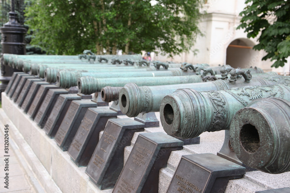 Historic cannon and balls in front of a church at the Kremlin. War and Peace united at the Kremlin. Historic cannon and balls in front of a church at the Kremlin. War and Peace united at the Kremlin.