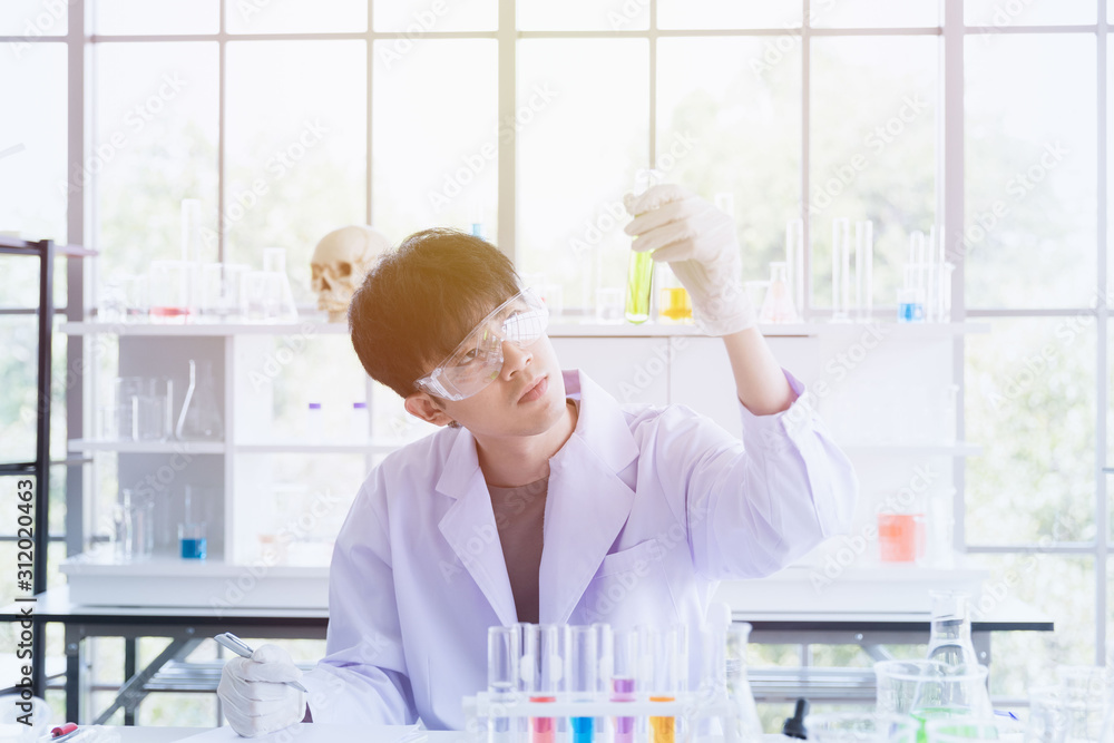 Scientist recording experiment result in lab room.. Scientist recording experiment result in lab room..