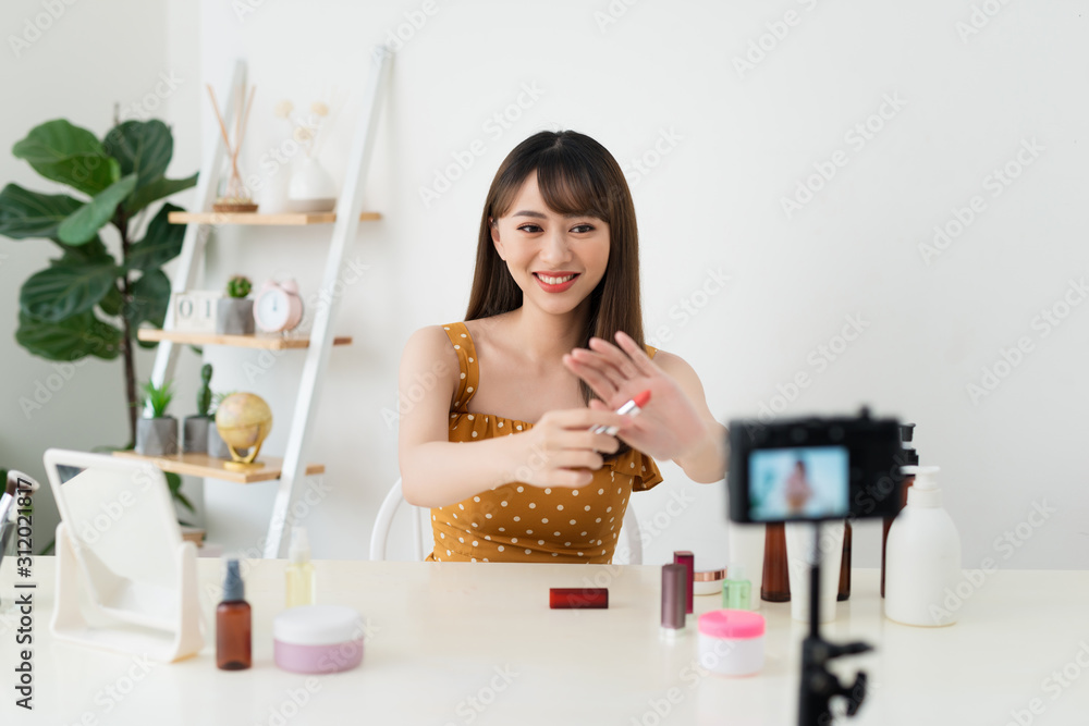 What is this. Pretty young woman sitting in front of the camera while testing cosmetics What is this. Pretty young woman sitting in front of the camera while testing cosmetics