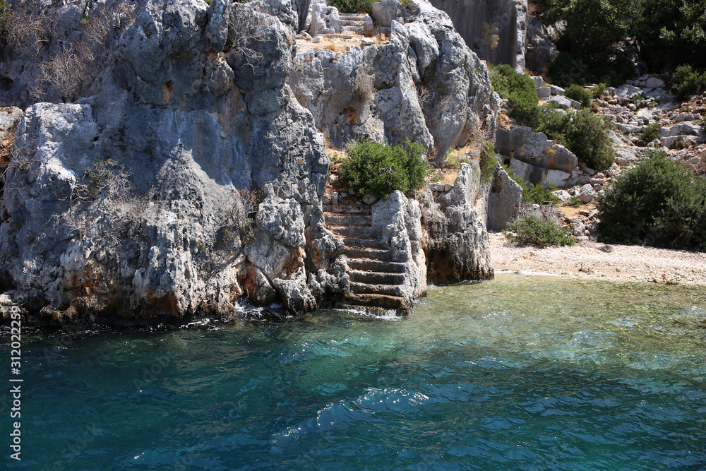 Ancient stone steps of a sunken antique city on the rocky coast of the island of Kekova in the Mediterranean Sea.