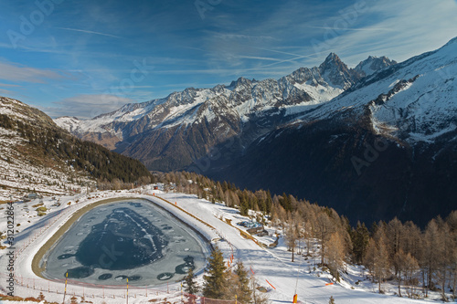 Frozen pond in the French alps with mountains in the background © pixilatedplanet