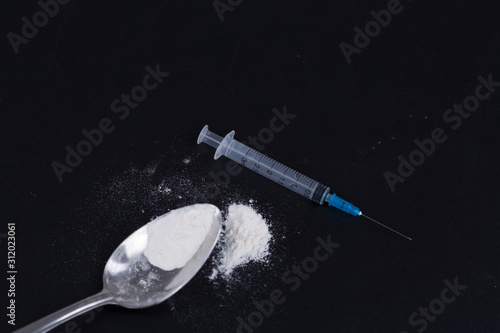 Фотография White pill, syringe and heroin on spoon. Drug addiction.