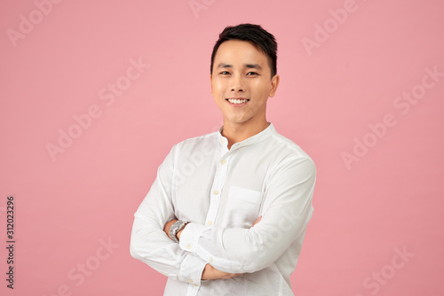 Young Asian male smiling and laughing with arms crossed