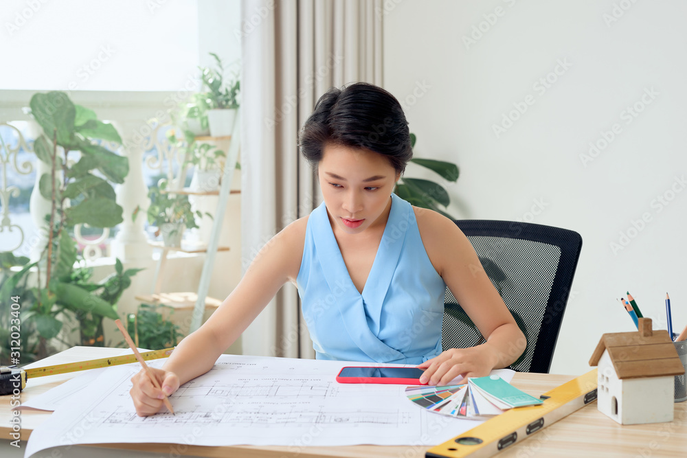 Famale architect looking at project at office Famale architect looking at project at office