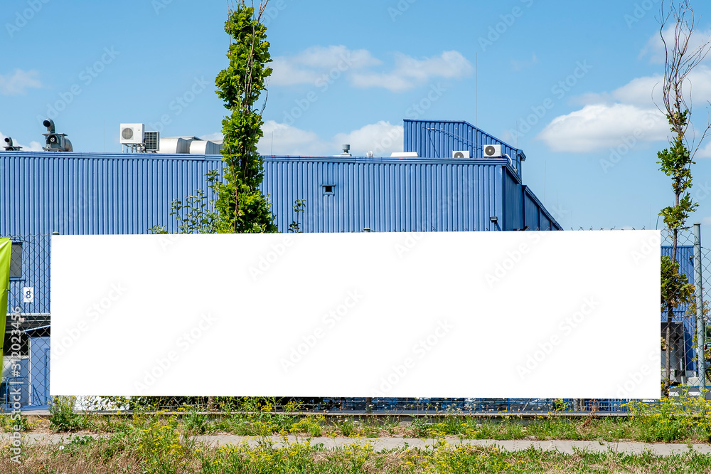 Blank white banner for advertisement mounted on the fance of warehouse building Blank white banner for advertisement mounted on the fance of warehouse building