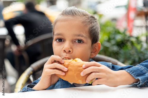 little boy eats sandwich fast food restaurant