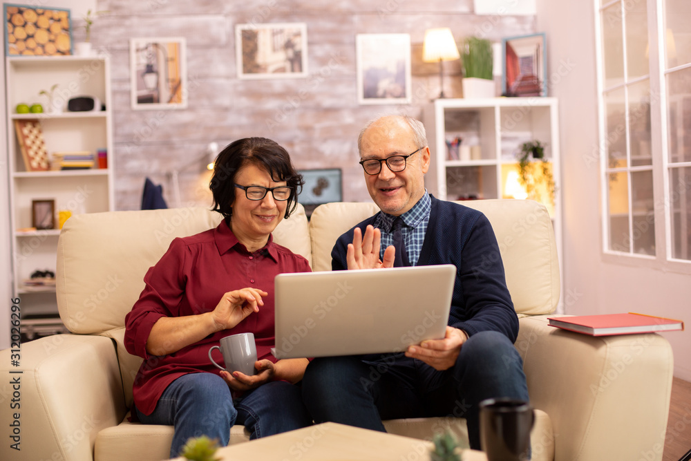 Elderly old couple using modern laptop to chat with their grandson Elderly old couple using modern laptop to chat with their grandson