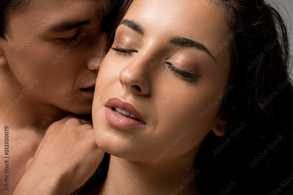 beautiful sensual young couple hugging with closed eyes isolated on grey beautiful sensual young couple hugging with closed eyes isolated on grey