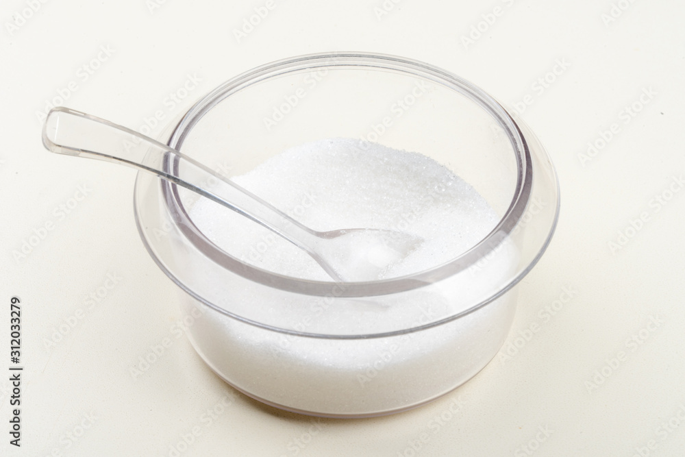 A cup of transparent plastic sugar and spoon A cup of transparent plastic sugar and spoon