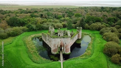 Aerial, rising, drone shot tilting towards the Caerlaverock Castle, at a cloudy day, in south Scotland photo