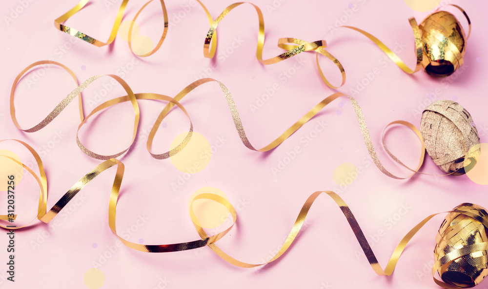 Obraz premium Three Bright Golden Gift Ribbons on Pink Background Holidays Festive Flat Lay Top View Minimal Concept Serpantine Horizontal Toned