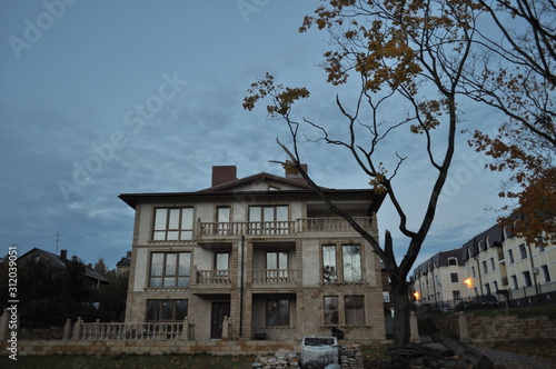 Beautiful evening view of the house through a young tree.