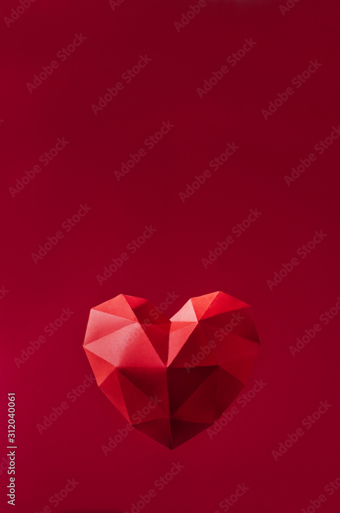 Paper geometric volume heart on red background with copy space
