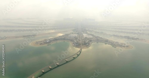 Aerial view of Jumeirah Palm Island Development In Dubai. Sunrise with fog conditions. The one and only the Palm in UAE. photo