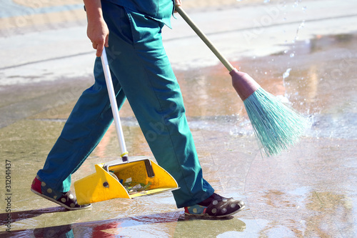 janitor cleans the sidewalk of the city