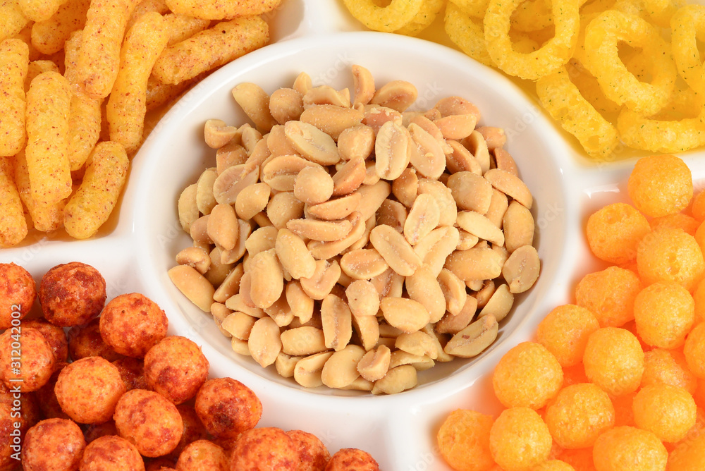 Mix of snacks on a white plate isolated on white. Mix of snacks on a white plate isolated on white.