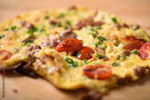 Thai style minced pork omelette on a brown wooden background