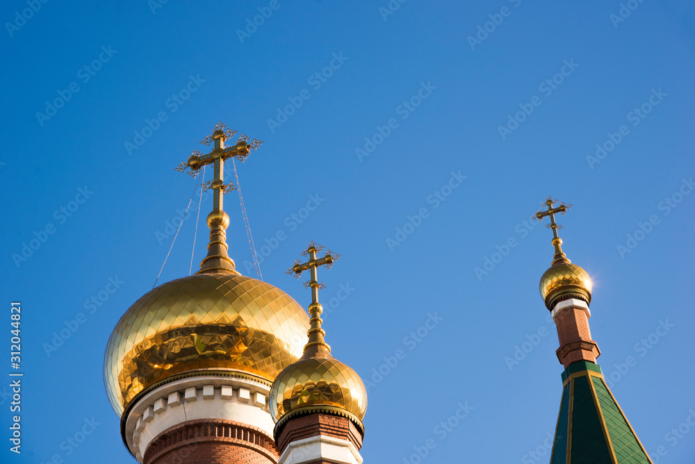 Three domes of the Orthodox Church against the blue sky. Religious architecture