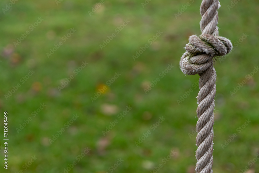 Starkes Hanfseil als Kletterseil mit Knoten im Garten als Spielplatz für Kinder und Jugendliche als Geschicklichkeitstraining und Bewegungsspiel mit frischer Luft draußen auf der Wiese Starkes Hanfseil als Kletterseil mit Knoten im Garten als Spielplatz für Kinder und Jugendliche als Geschicklichkeitstraining und Bewegungsspiel mit frischer Luft draußen auf der Wiese