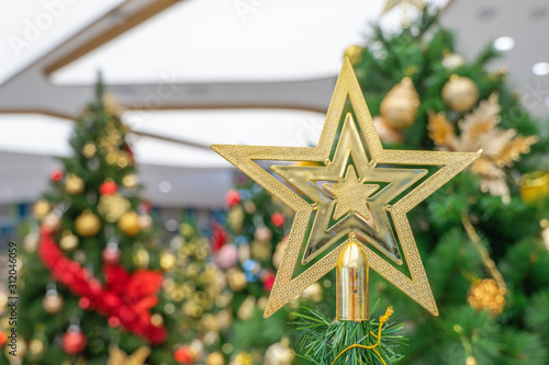 Beautiful Christmas star hanging from a decorated Christmas tree