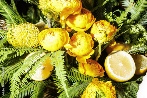 Fototapeta Naklejka Na Ścianę i Meble -  Lemons and yellow peony on a plate. Exotic tropic banquet decoration. Top view, closeup