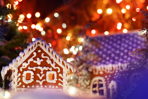 Gingerbread houses among the magical winter scenery. Sparkling lights in the background. Magical festive winter setting scenery.
