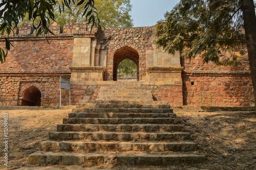 A step ladder of sikandar lodhi monument at lodi garden or lodhi gardens in a city park from the side of the lawn at winter foggy morning. photo