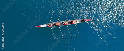 Aerial drone ultra wide photo of sport canoe with young team of athletes practising in deep blue open ocean sea