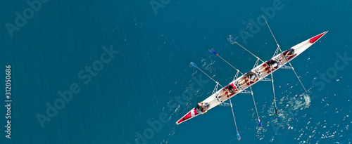 Aerial drone ultra wide photo with copy space of sport canoe with young team of athletes practising in deep blue open ocean sea