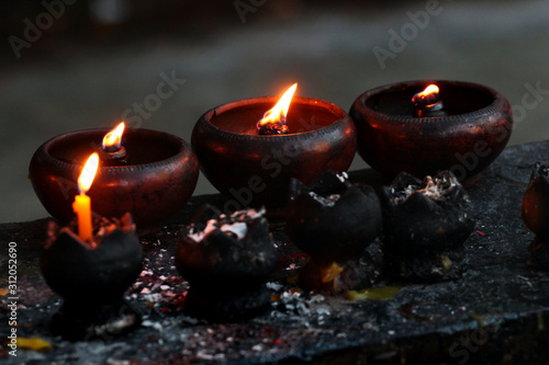 Burning candles and oil lamps in a buddhist temple in Thailand