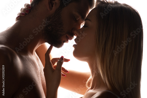 close up of seductive woman kissing sensual man, isolated on white
