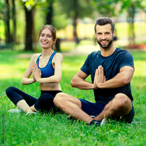Portrait of young couple or woman training with male bearded instructor, doing yoga exercises or meditating together, outdoor. Square composition picture.