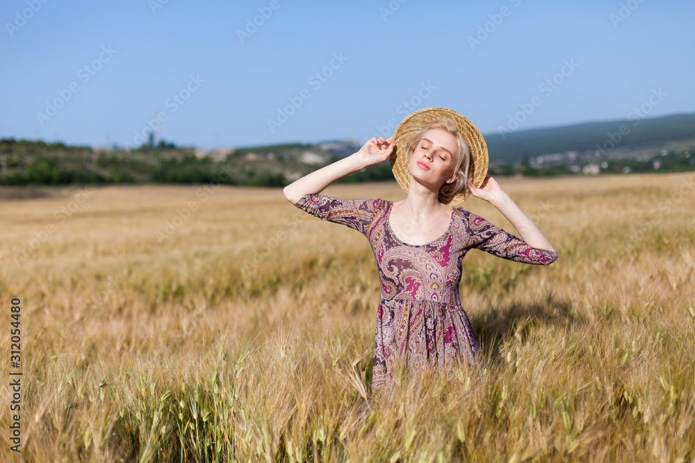 portrait of a beautiful fashionable blonde woman in a hat in a field of ripe wheat portrait of a beautiful fashionable blonde woman in a hat in a field of ripe wheat