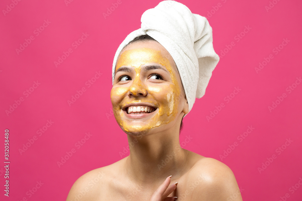 Beauty portrait of woman in white towel on head with gold nourishing mask on face. Skincare cleansing eco organic cosmetic spa relax concept. Beauty portrait of woman in white towel on head with gold nourishing mask on face. Skincare cleansing eco organic cosmetic spa relax concept.