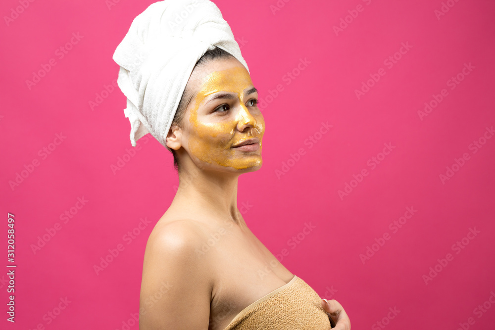 Beauty portrait of woman in white towel on head with gold nourishing mask on face. Skincare cleansing eco organic cosmetic spa relax concept. Beauty portrait of woman in white towel on head with gold nourishing mask on face. Skincare cleansing eco organic cosmetic spa relax concept.