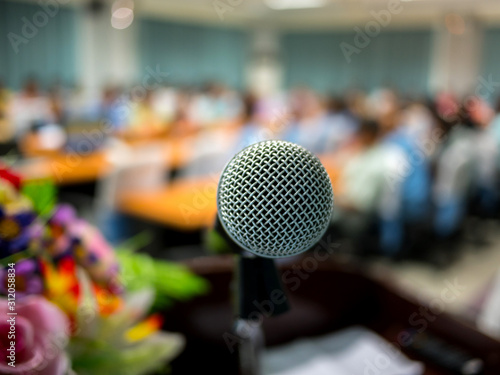 Close up Microphone over the Abstract blurred photo of meeting room or seminar room background.